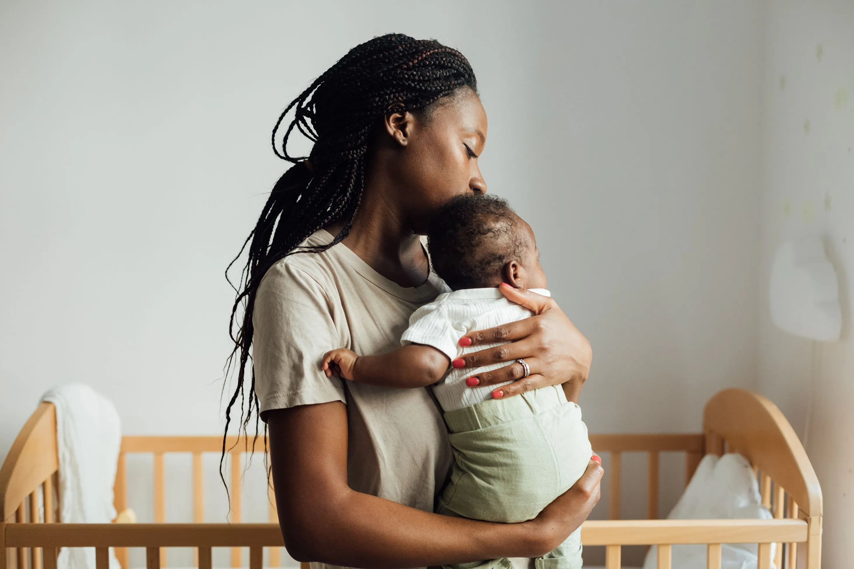 mother holding baby in nursery